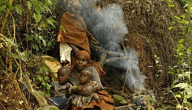 Batwa family at a traditional forest shelter on the cultural trail
