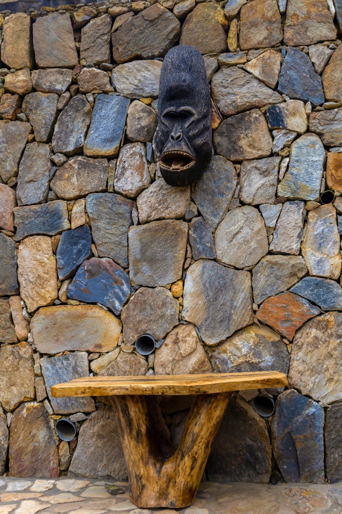 Hand-carved gorilla mask on stone lodge wall