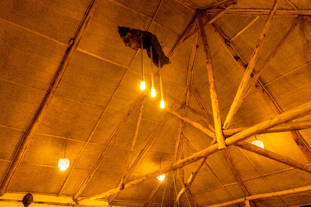 Rustic vaulted ceiling with woven panels and pendant lights